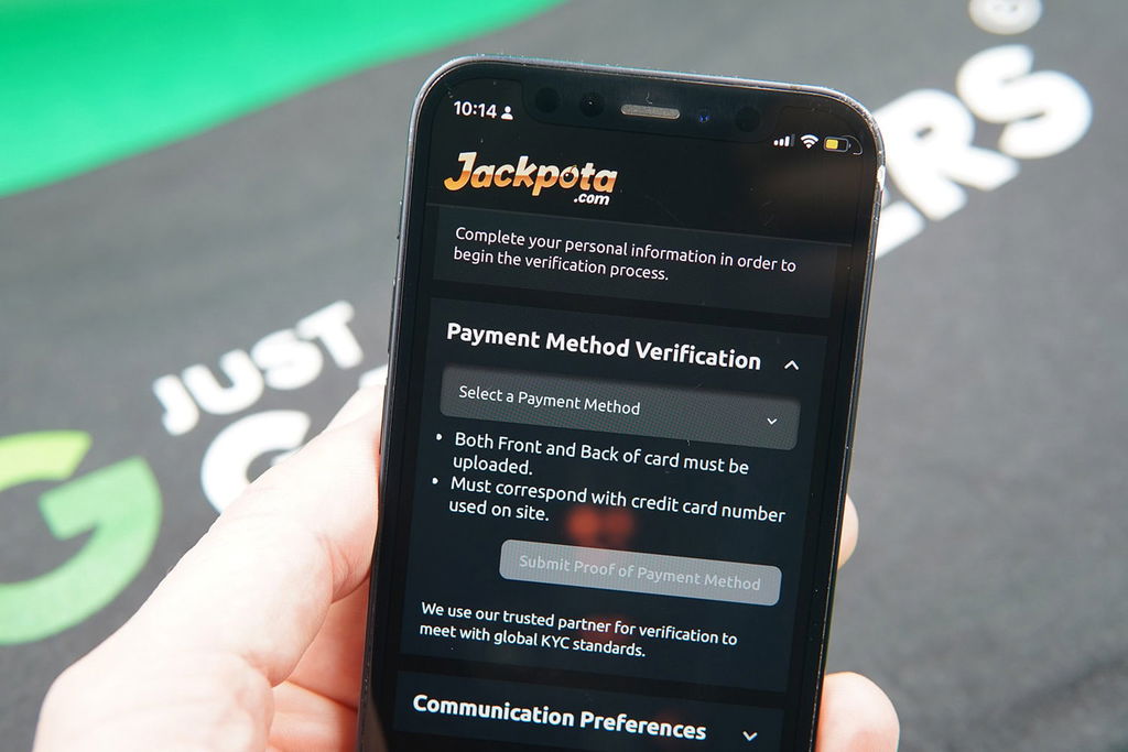 Patrik Lidin holding an iPhone showing the Jackpota KYC process.