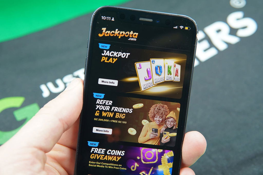 Patrik Lidin holding an iPhone with the Jackpota rewards page loaded on the webpage.