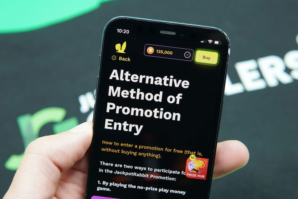 Patrik Lidin holding an iPhone with the JackpotRabbit casino AMOE page loaded on the webpage.