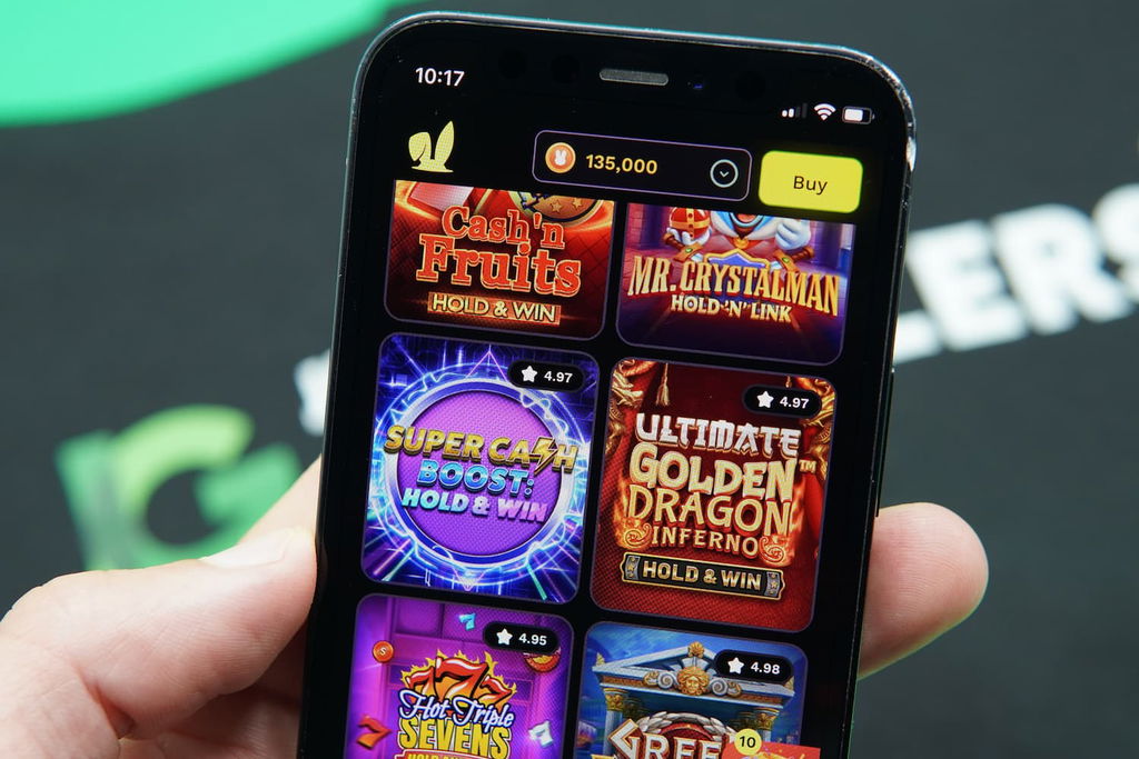 Patrik Lidin holding an iPhone with the JackpotRabbit casino Game Library page loaded on the webpage.