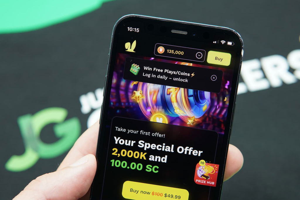 Patrik Lidin holding an iPhone with the JackpotRabbit casino Landing Page loaded on the webpage.