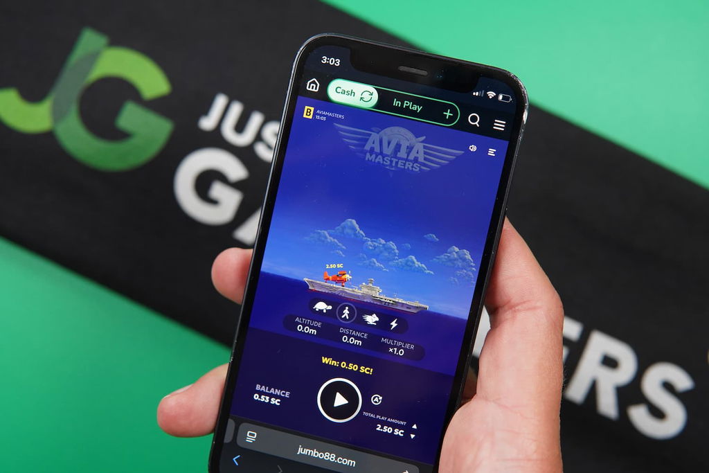 Patrik Lidin holding an iPhone with the Jumbo88 casino mobile game page loaded on the webpage.