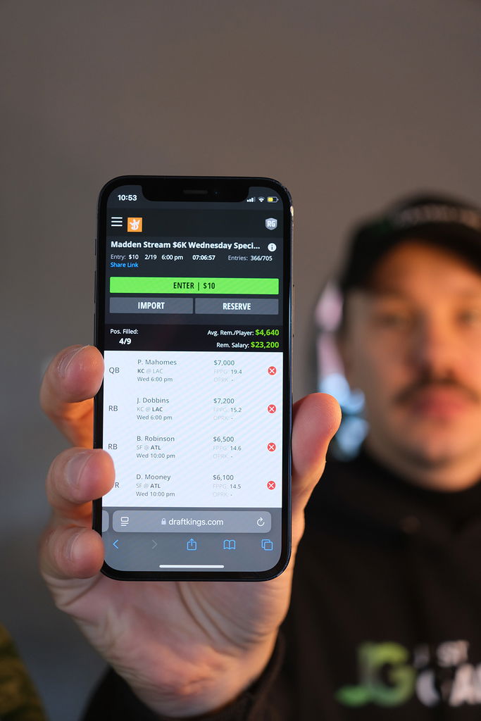 Photo of Patrik Lidin holding an iPhone showing a daily fantasy site site.