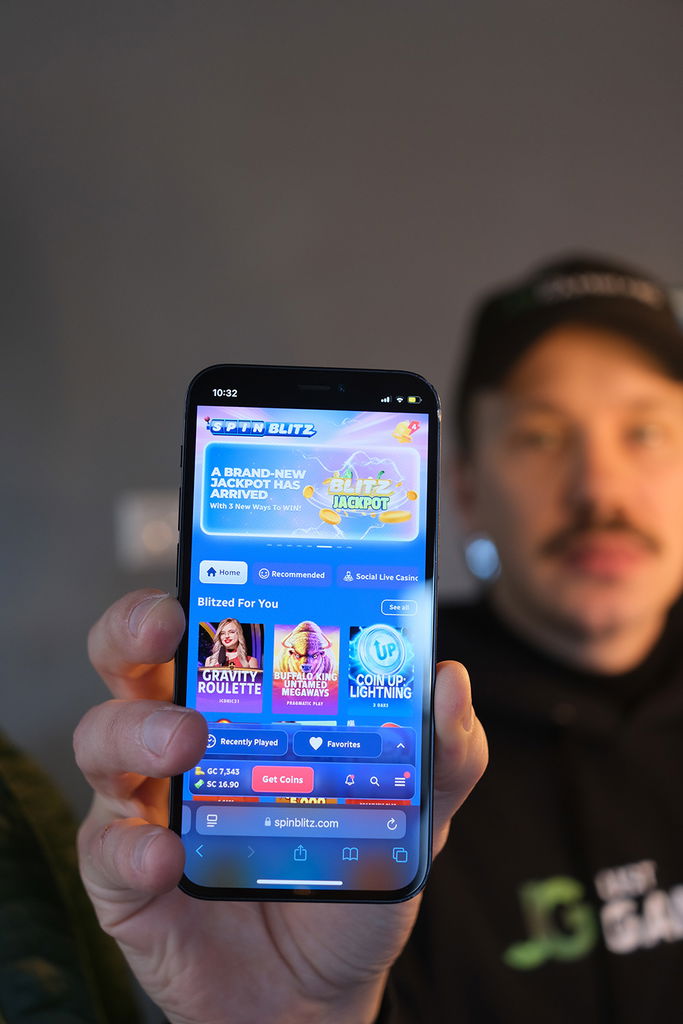Photo of Patrik Lidin holding an iPhone showing a sweepstakes casino site.