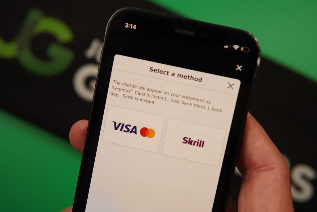 Patrik Lidin holding an iPhone with the Legendz casino mobile payment page loaded on the webpage.