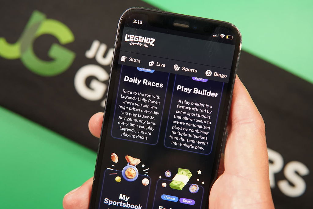 Patrik Lidin holding an iPhone with the Legendz casino promotions page loaded on the webpage.
