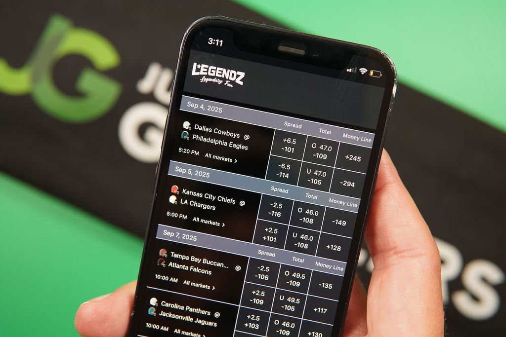 Patrik Lidin holding an iPhone with the Legendz casino sportsbook page loaded on the webpage.