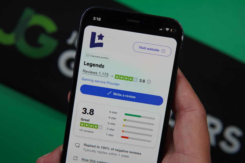 Patrik Lidin holding an iPhone with the Legendz casino Trustpilot page loaded on the webpage.