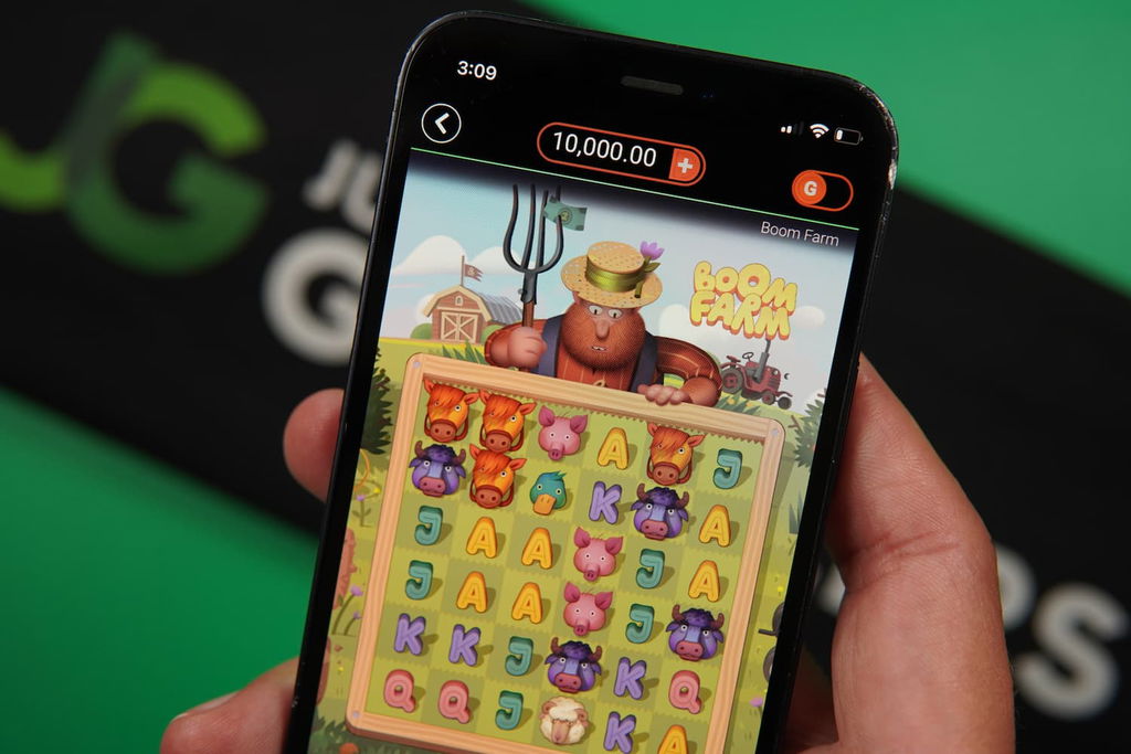 Patrik Lidin holding an iPhone with the LoneStar casino in-game mobile page loaded on the webpage.