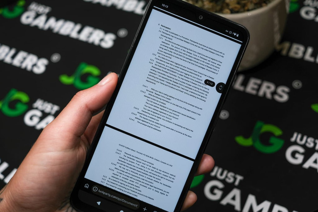Angela Zillich holding an Android Phone with Luck Party casino AMOE page loaded on the webpage.