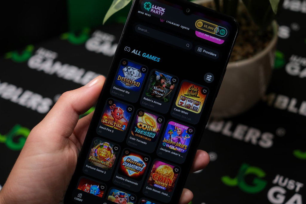 Angela Zillich holding an Android Phone with Luck Party casino Gaming Library page loaded on the webpage.