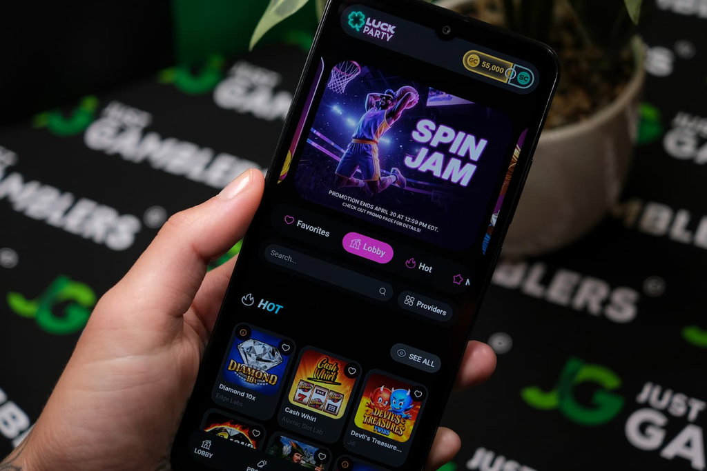 Angela Zillich holding an Android Phone with Luck Party casino Landing page loaded on the webpage.
