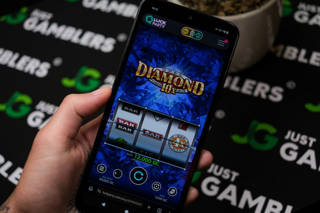 Angela Zillich holding an Android Phone with Luck Party casino Mobile in-Game page loaded on the webpage.