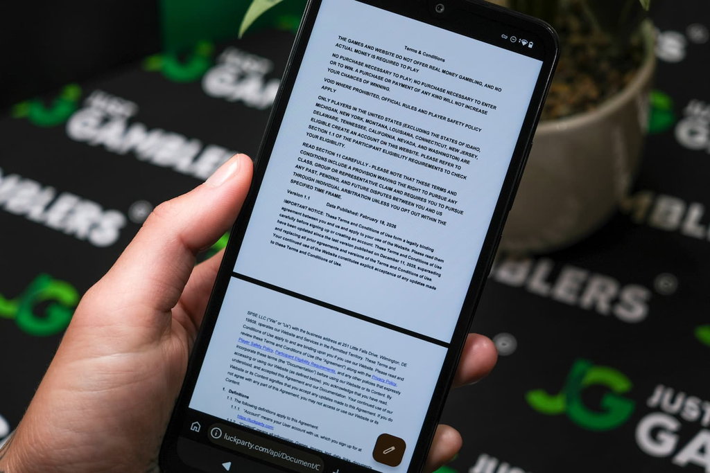 Angela Zillich holding an Android Phone with Luck Party casino Terms and Conditions page loaded on the webpage.
