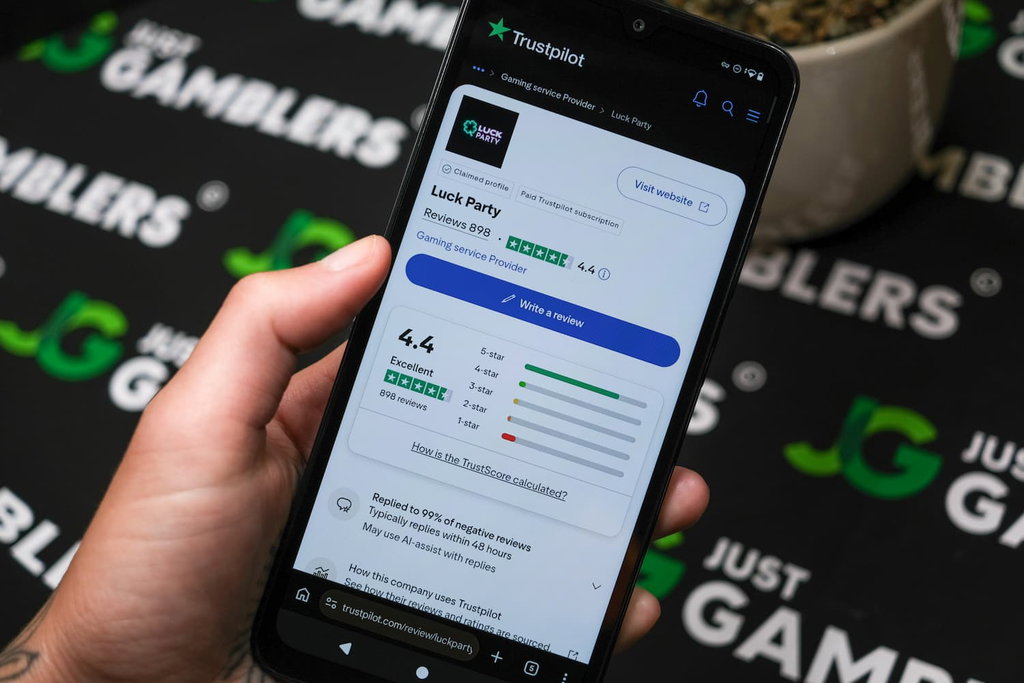 Angela Zillich holding an Android Phone with Luck Party casino Trustpilot ratings page loaded on the webpage.