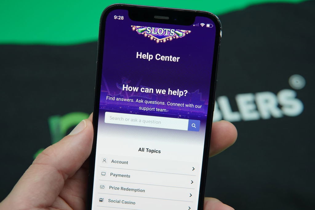 Patrik Lidin holding an iPhone with the LuckyLand casino customer support page loaded on the webpage.