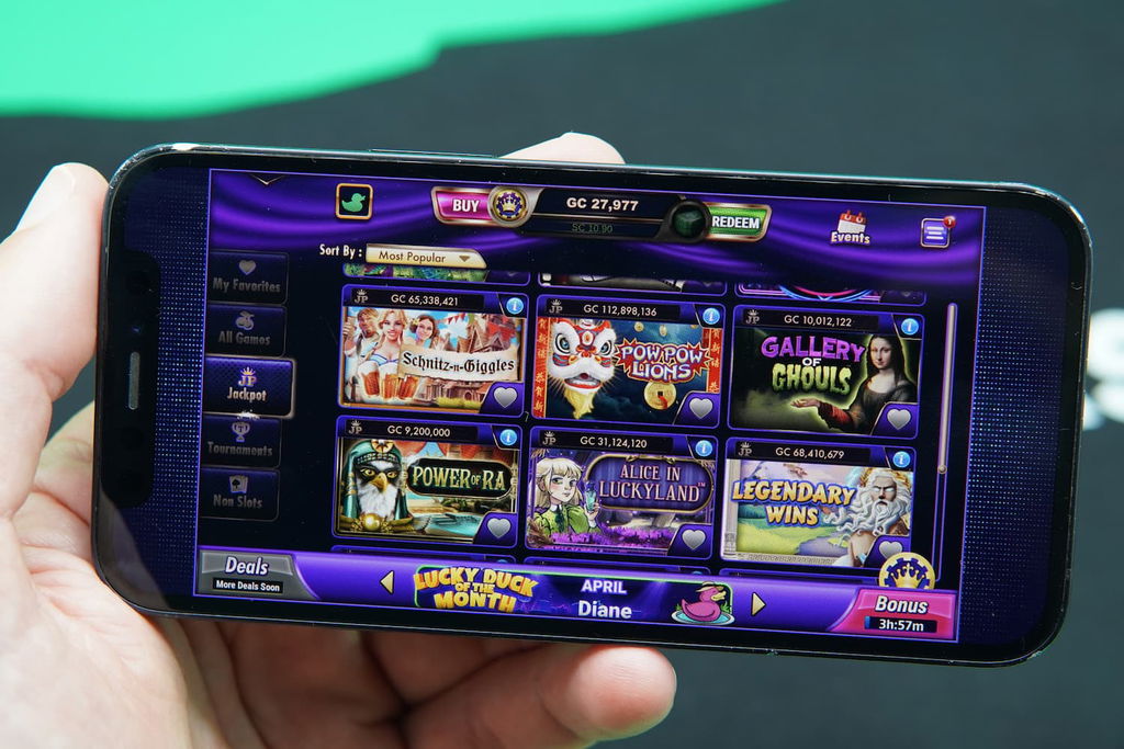Patrik Lidin holding an iPhone with the LuckyLand casino game library page loaded on the webpage.