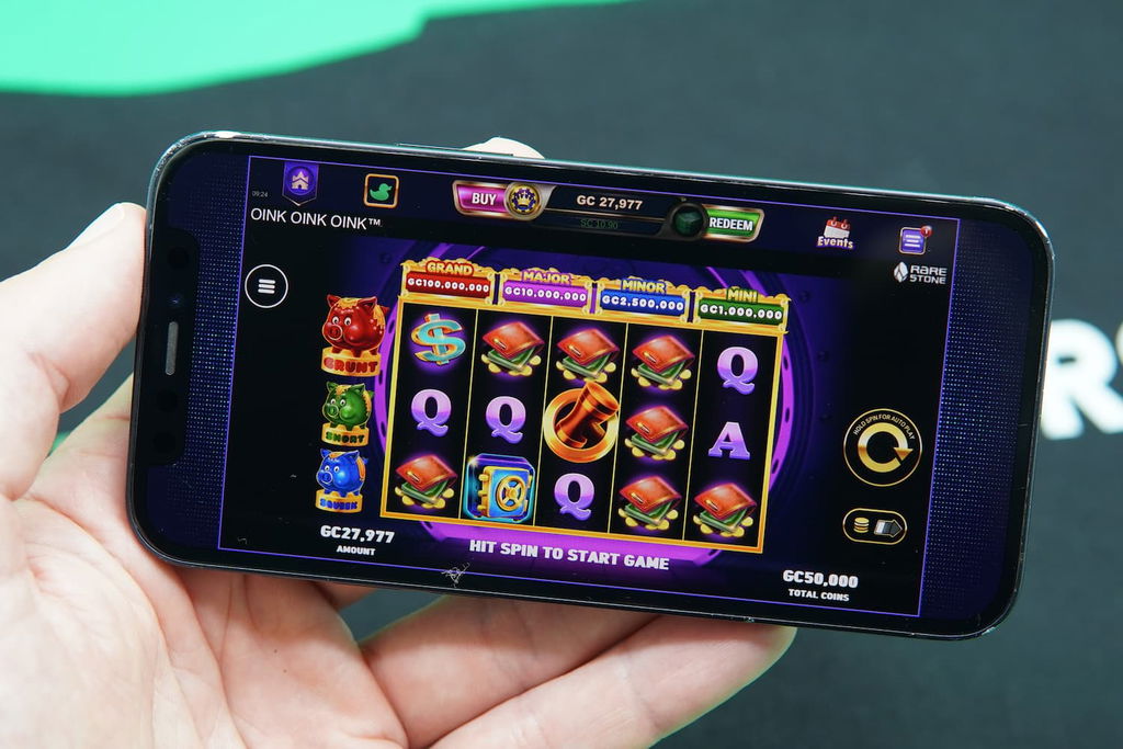 Patrik Lidin holding an iPhone with the LuckyLand casino in-game mobile page loaded on the webpage.