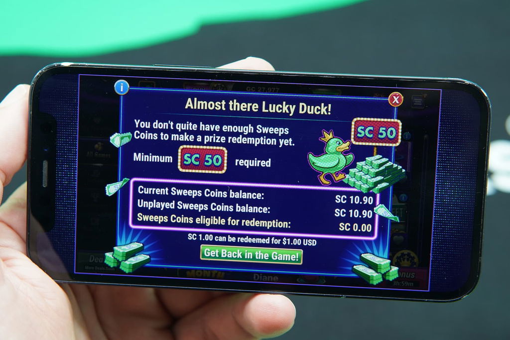 Patrik Lidin holding an iPhone with the LuckyLand casino redemptions page loaded on the webpage.