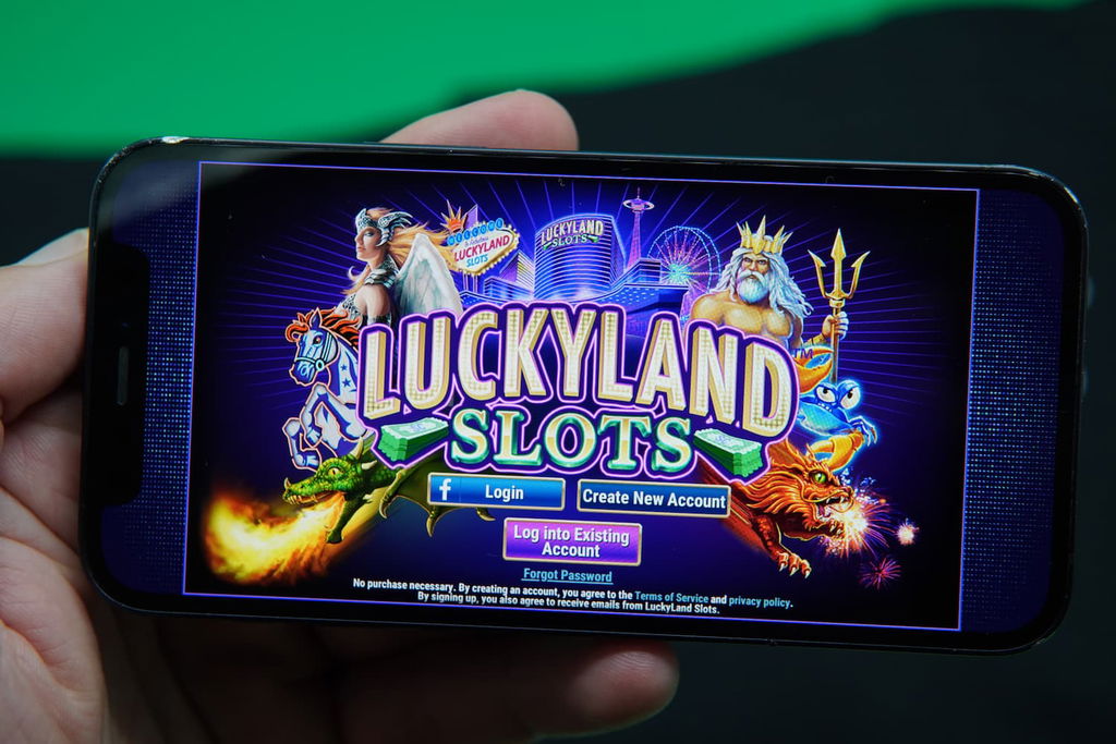 Patrik Lidin holding an iPhone with the LuckyLand casino registration page loaded on the webpage.