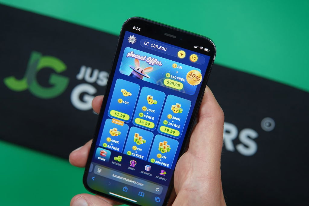 Patrik Lidin holding an iPhone with the Lunaland casino purchases page loaded on the webpage.