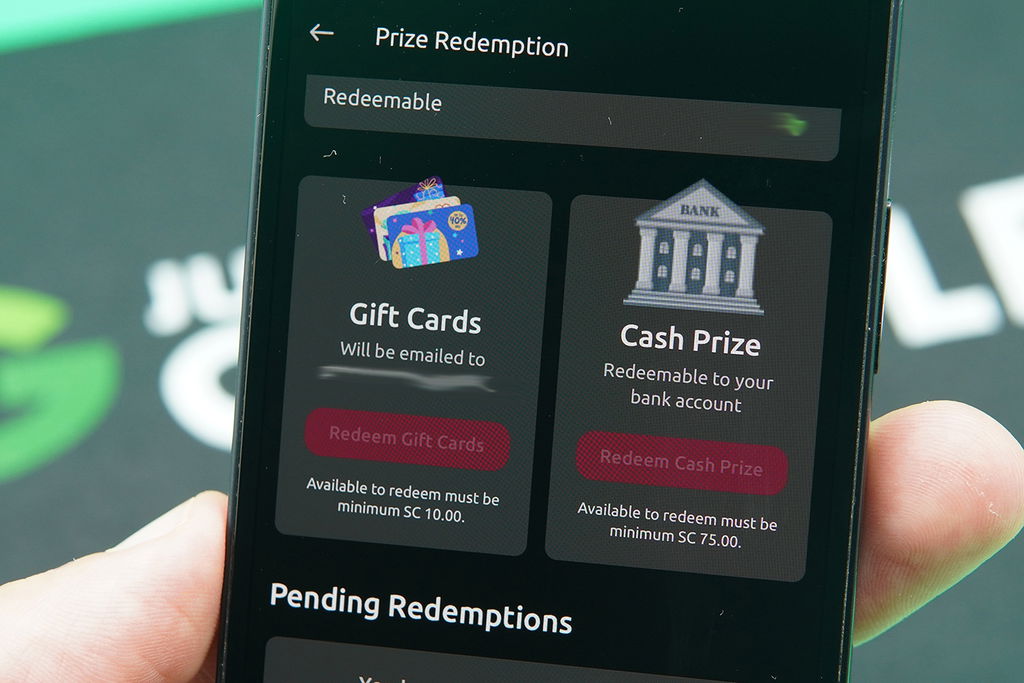 Patrik Lidin holding an iPhone with the McLuck redemptions loaded on the webpage.