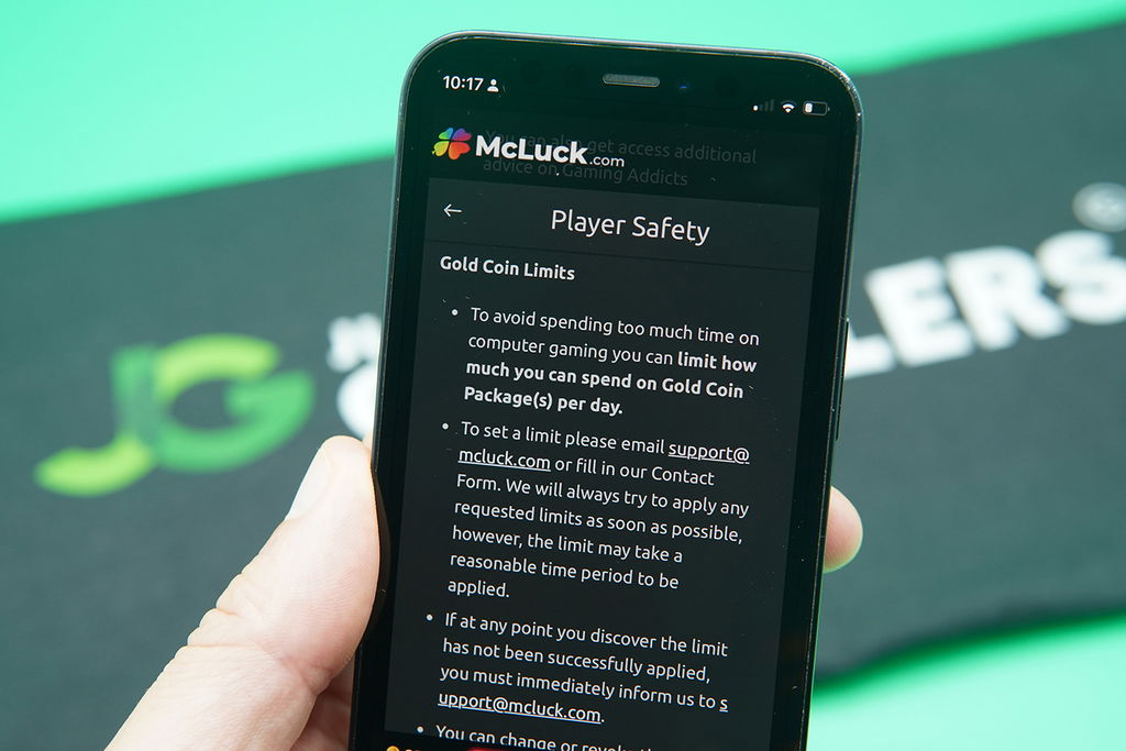 Patrik Lidin holding an iPhone with the McLuck responsible gambling page showing.