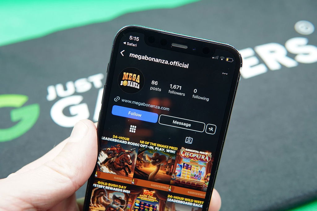Patrik Lidin holding an iPhone with the Mega Bonanza Instagram account.