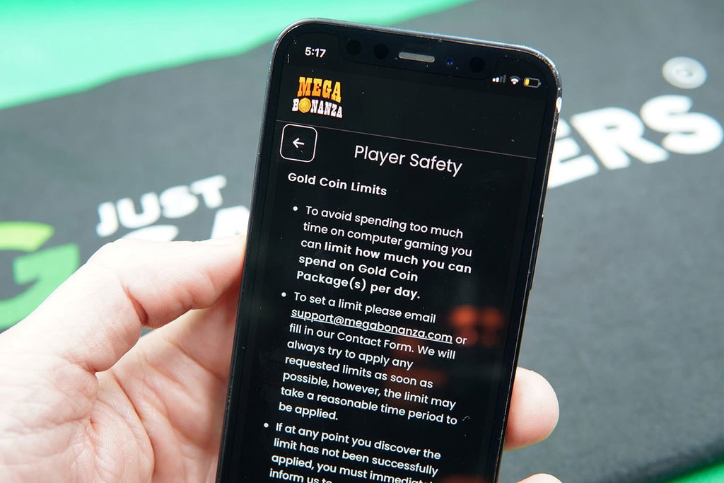 Patrik Lidin holding an iPhone with the Mega Bonanza responsible gambling page showing.