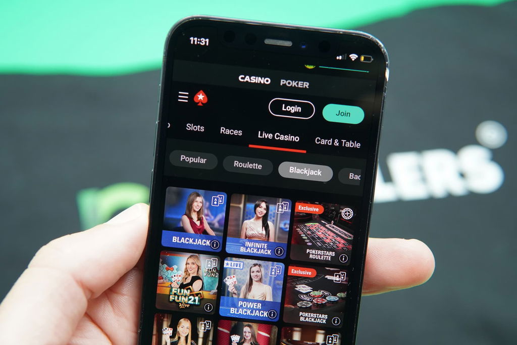 Photo of Patrik Lidin holding an iPhone with an MI online gambling site showing.