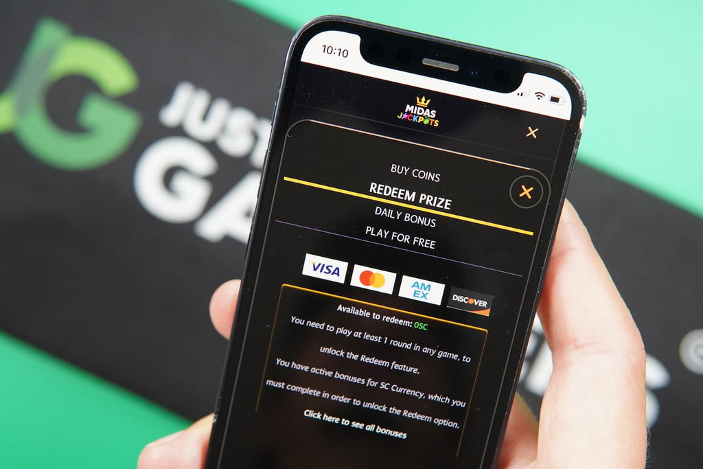 Patrik Lidin holding an iPhone with the Midas Jackpots casino redemptions page loaded on the webpage.