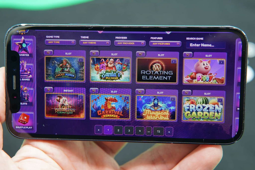 Patrik Lidin holding an iPhone with the Milky Star Slots casino game library page loaded on the webpage.