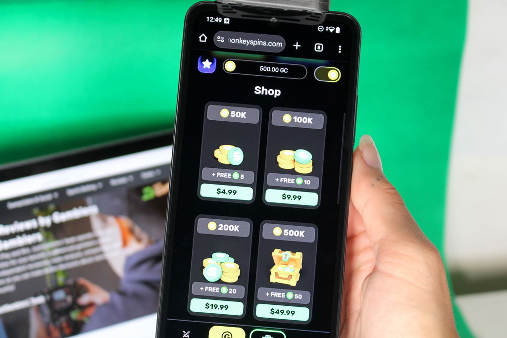 Angela Zillich holding an iPhone with the Monkey Spins casino coin store page loaded on the webpage.