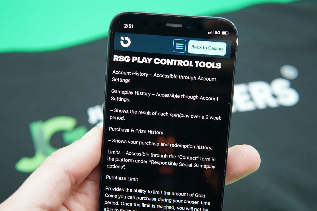 Patrik Lidin holding an iPhone with the Moonspin responsible gambling page loaded on the webpage.