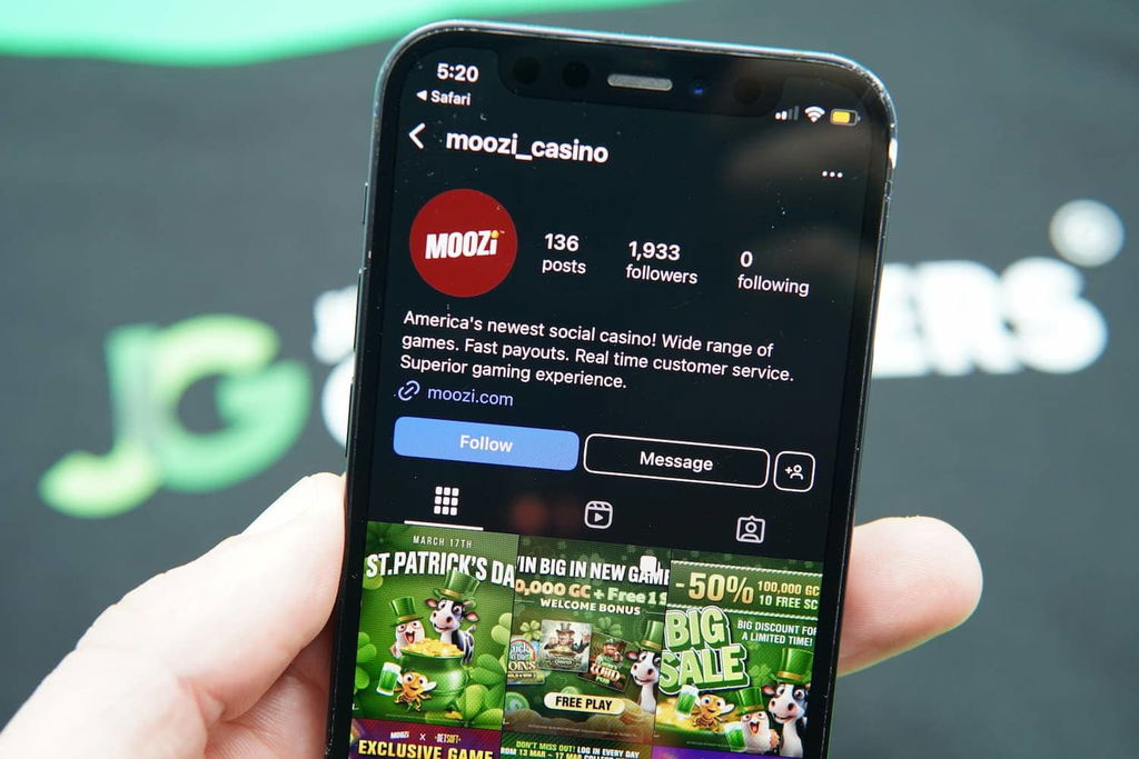 Patrik Lidin holding an iPhone with the Moozi casino Instagram page loaded on the webpage.
