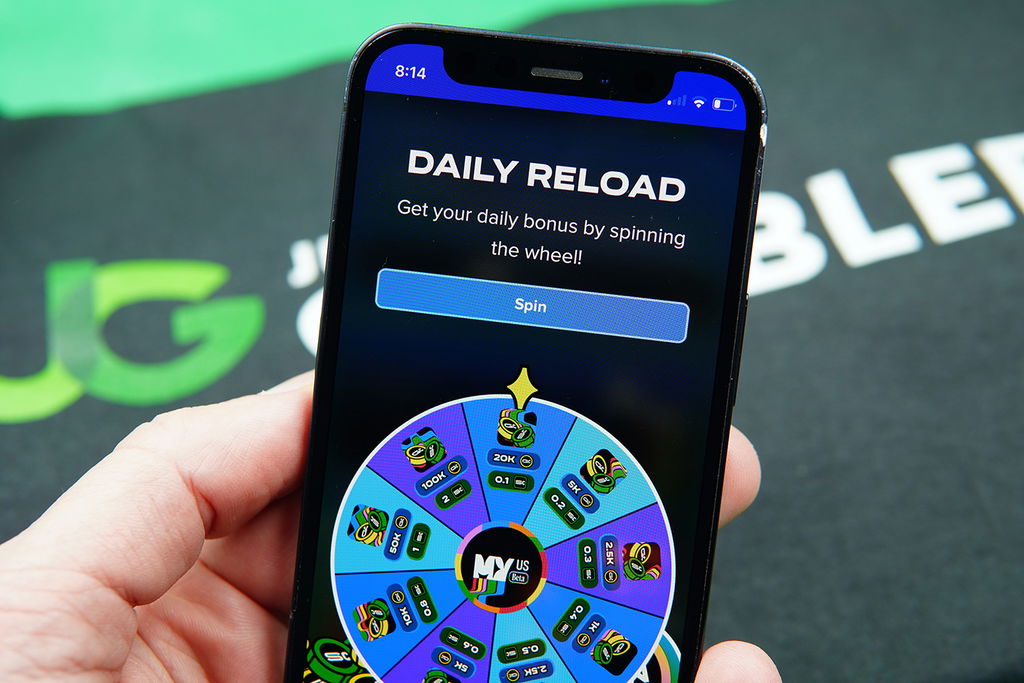 Patrik Lidin holding an iPhone showing the MyPrize US daily reward on the webpage.