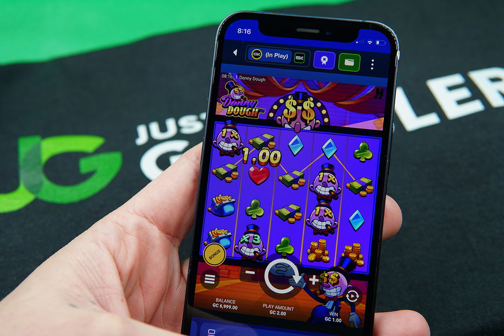 Patrik Lidin holding an iPhone with McLuck casino game Donny Dough showing.