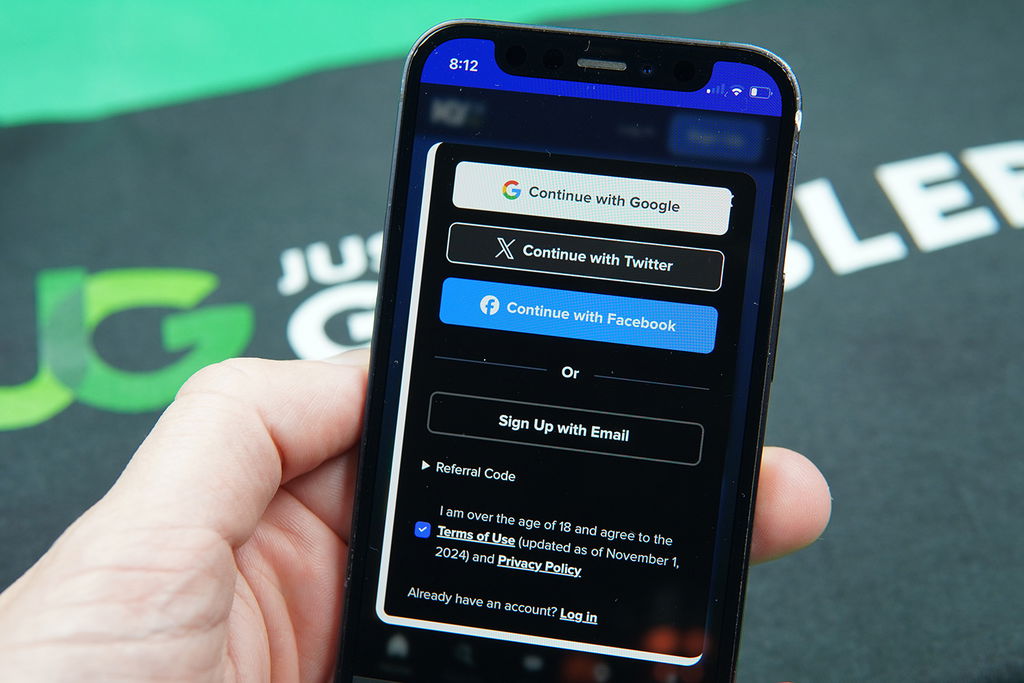 Patrik Lidin holding an iPhone showing the MyPrize US registration process.