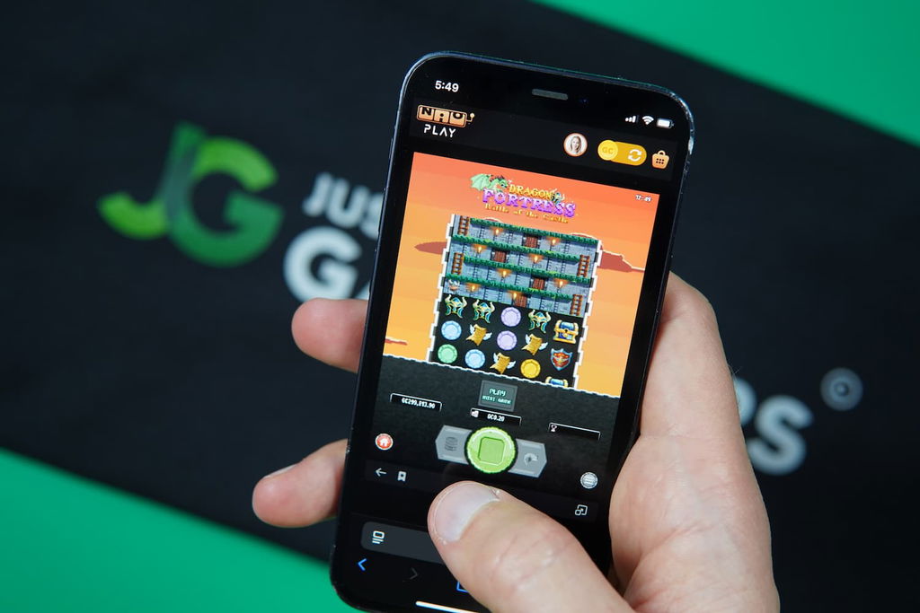 Patrik Lidin holding an iPhone with the Nioplay casino in-game mobile page loaded on the webpage.