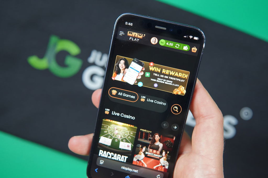 Patrik Lidin holding an iPhone with the Nioplay casino landing page loaded on the webpage.