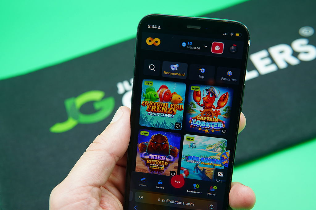 Patrik Lidin holding an iPhone with NoLimitCoins game library showing.