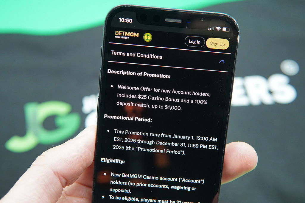 Photo of Patrik Lidin holding iPhone with an example of NJ online casino bonus terms and conditions.