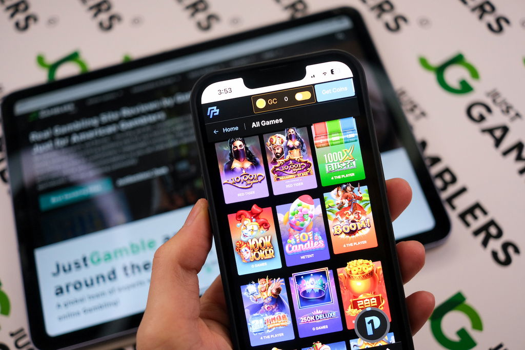 Angela Zillich holding an iPhone with the PeakPlay casino gaming lobby page loaded on the webpage.