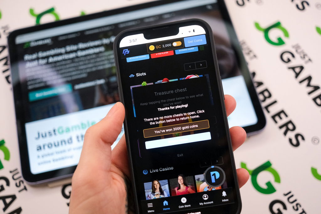 Angela Zillich holding an iPhone with the PeakPlay casino Treasure Chest winnings page loaded on the webpage.