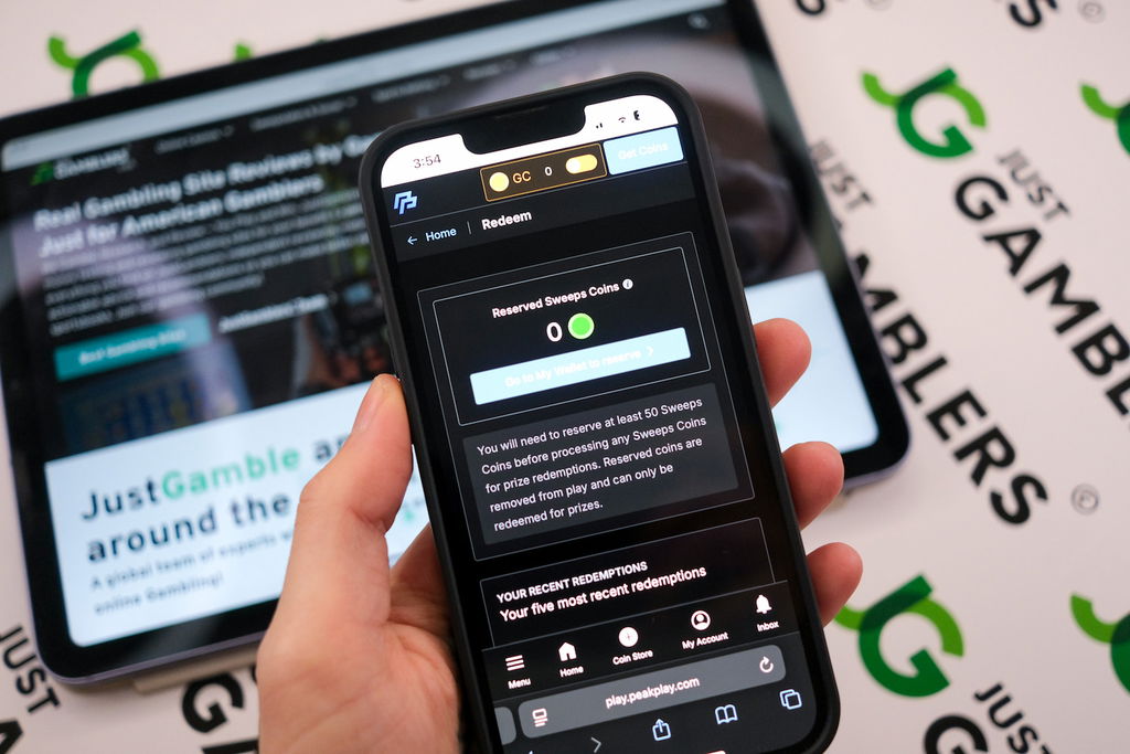 Angela Zillich holding an iPhone with the PeakPlay casino Redemptions page loaded on the webpage.