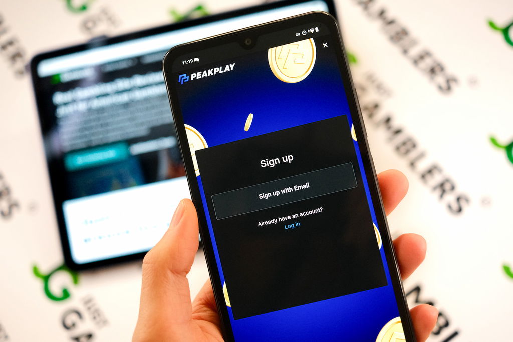 Angela Zillich holding an Android Phone with the PeakPlay casino registration page loaded on the webpage.