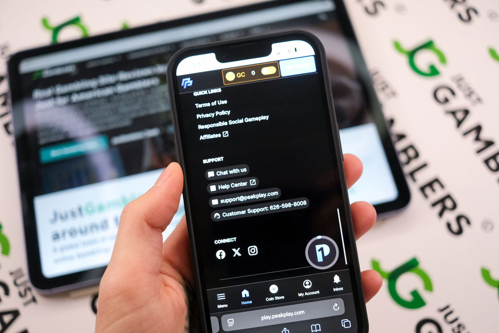 Angela Zillich holding an iPhone with the PeakPlay casino Support footer page loaded on the webpage.
