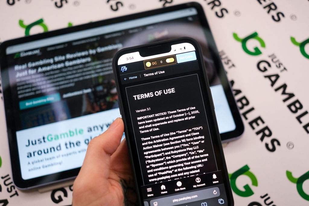 Angela Zillich holding an iPhone with the PeakPlay casino Terms of Use page loaded on the webpage.