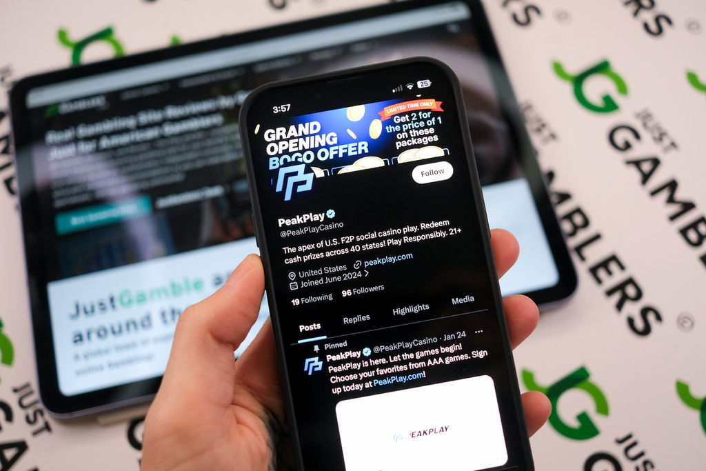 Angela Zillich holding an iPhone with the PeakPlay casino trust X page loaded on the webpage.