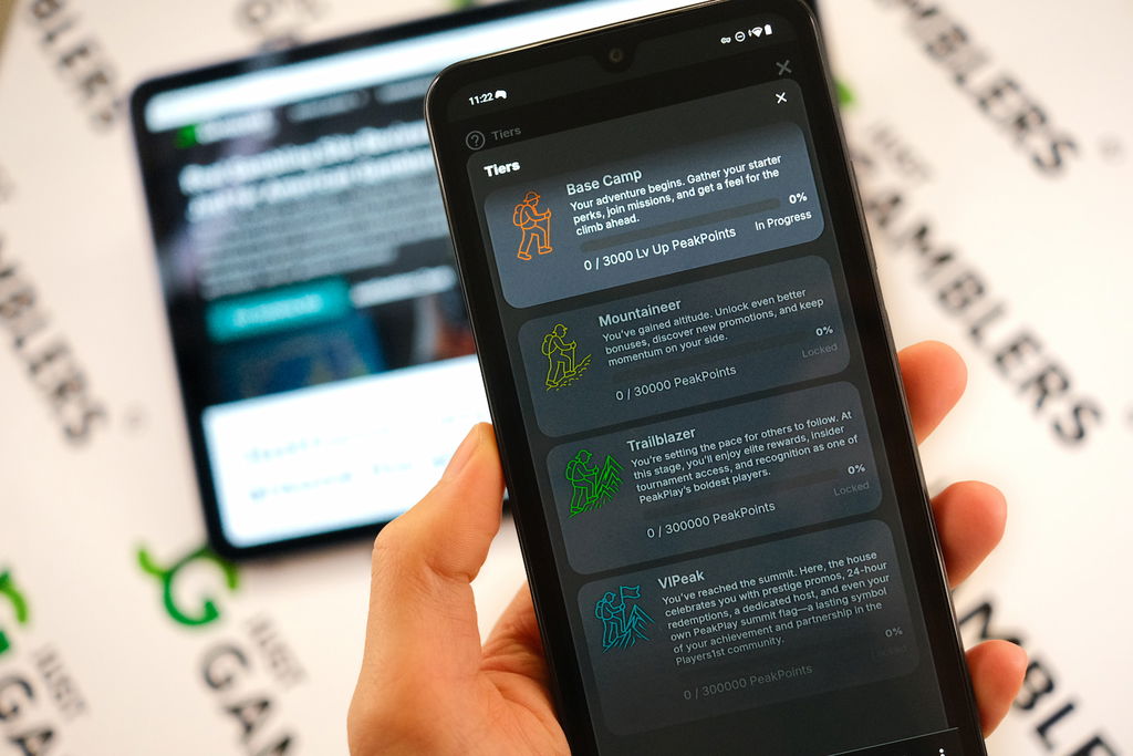Angela Zillich holding an Android Phone with the PeakPlay casino VIP page loaded on the webpage.